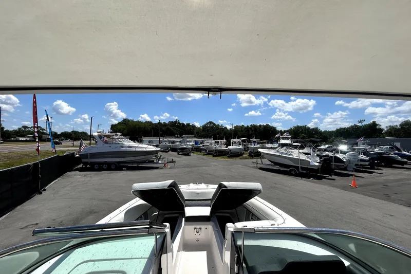 Slide: The Image of 2021 Regal 26 FasDeck boat in a marina with other boats under a sunny sky. - 74