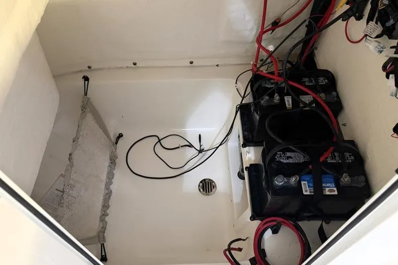 Slide: The Image of Battery compartment of 2025 Key West 239 FS boat with wiring and drainage. - 12