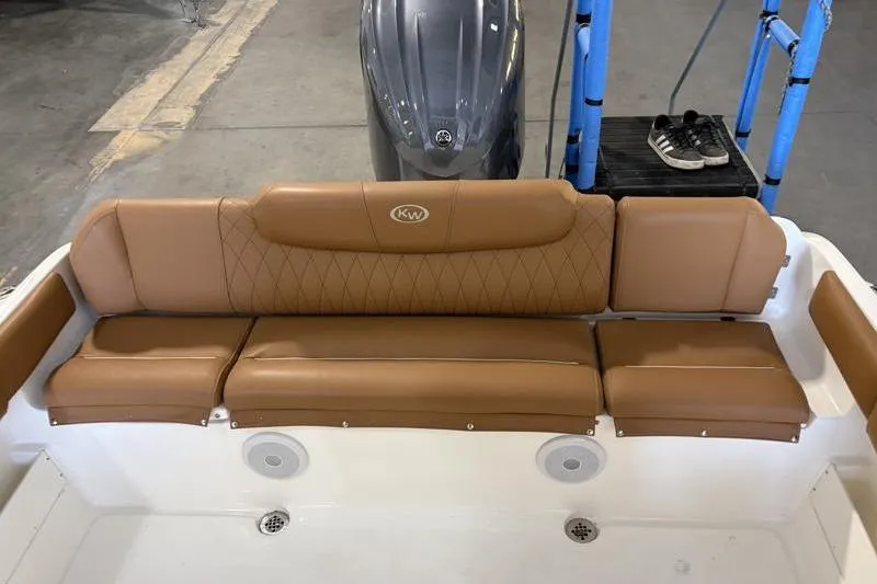 Slide: The Image of 2025 Key West 239 FS boat with tan leather seating and motor in a garage. - 18