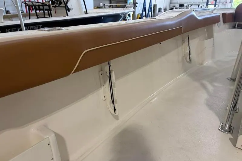 Slide: The Image of 2025 Key West 239 FS boat interior with tan cushioned side rail. - 21