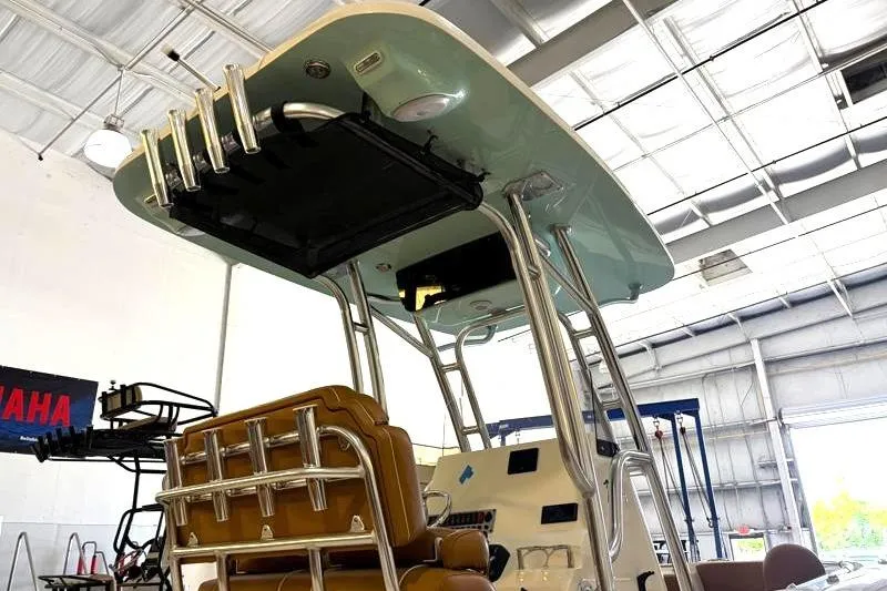 Slide: The Image of 2025 Key West 239 FS boat interior with rod holders and seating in a showroom. - 5