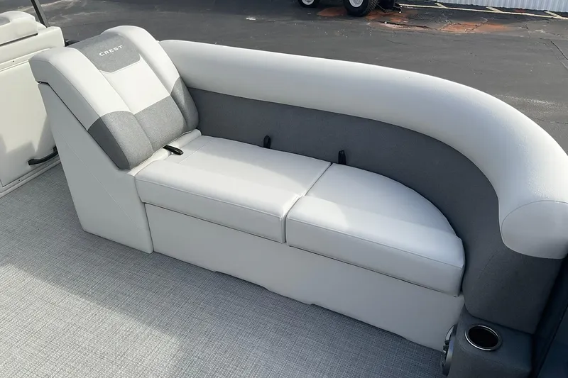 Slide: The Image of 2026 Crest Conquest SE 220 Cruise boat interior with gray and white cushioned seating. - 11