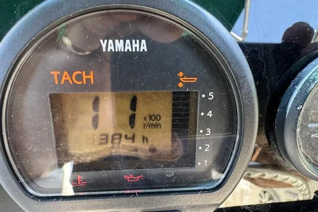 Slide: The Image of Yamaha tachometer displaying 384 hours on a 2000 Pursuit 2470 Walkaround boat. - 16