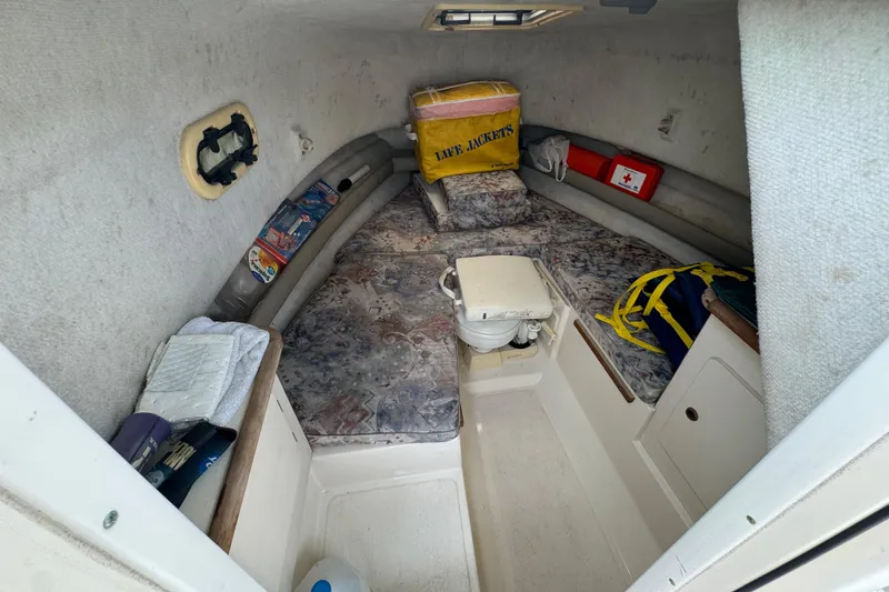 Slide: The Image of 2000 Pursuit 2470 Walkaround cabin interior with safety equipment and storage. - 24