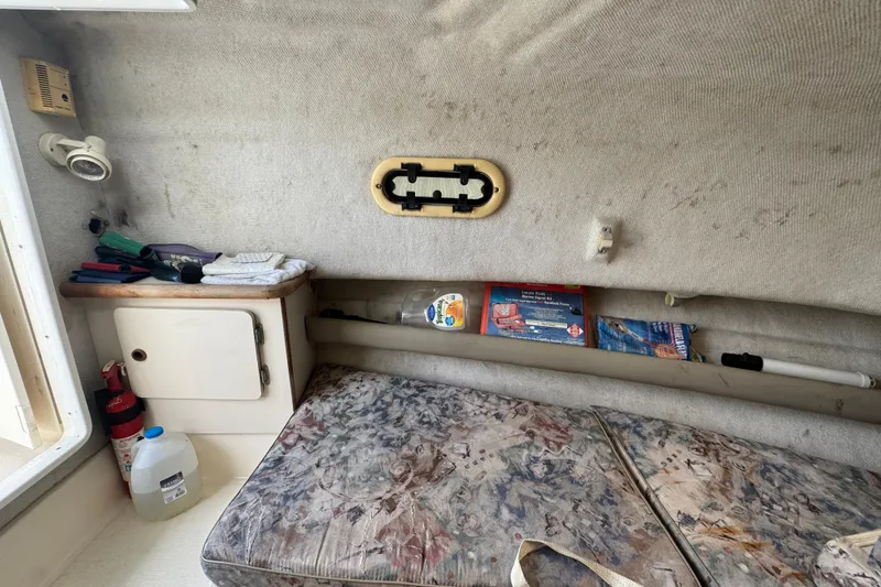 Slide: The Image of Interior cabin of a 2000 Pursuit 2470 Walkaround boat with storage and bedding. - 25