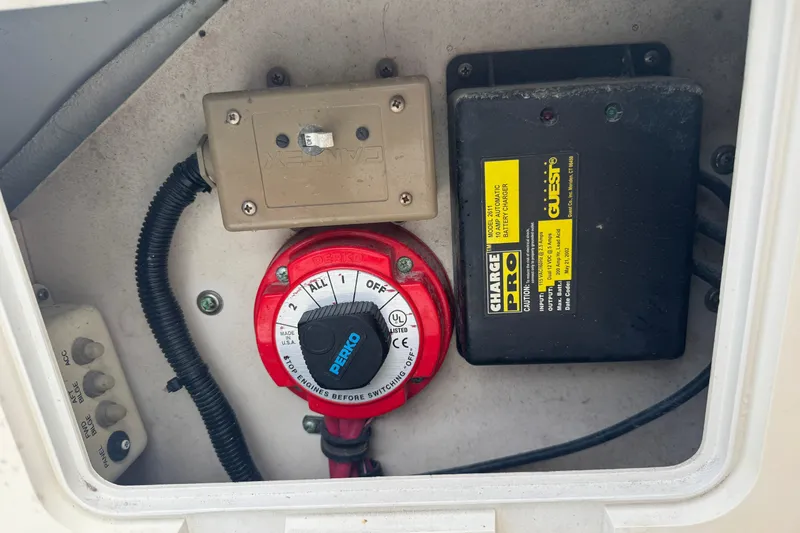 Slide: The Image of Battery switch and charger in a 2000 Pursuit 2470 Walkaround boat compartment. - 29