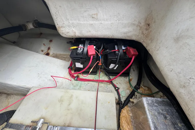 Slide: The Image of Battery compartment of a 2000 Pursuit 2470 Walkaround boat with visible wiring. - 33