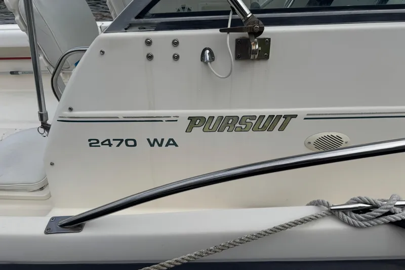 Slide: The Image of 2000 Pursuit 2470 Walkaround boat side view with model name and logo. - 37