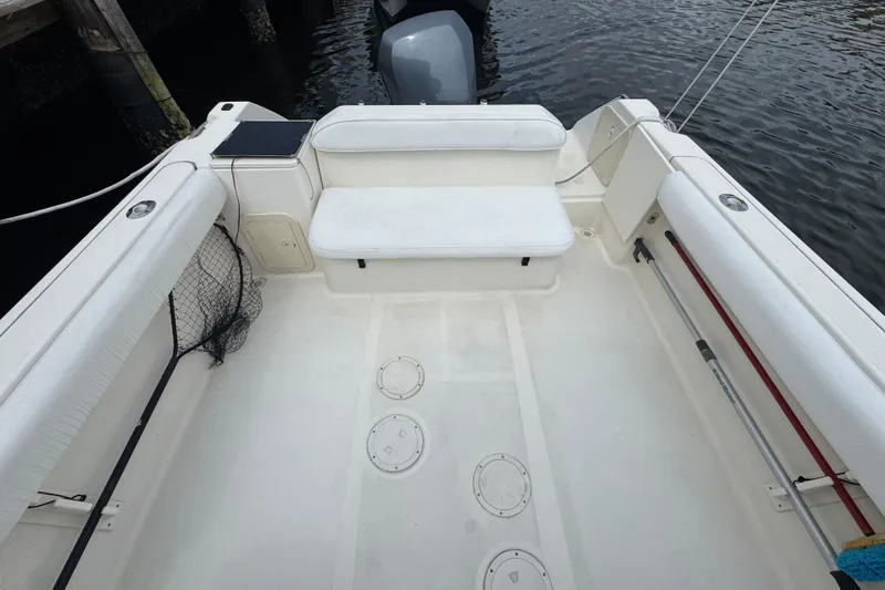Slide: The Image of 2000 Pursuit 2470 Walkaround boat interior with seating and fishing gear. - 6