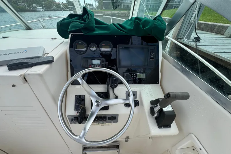 Slide: The Image of Helm of 2000 Pursuit 2470 Walkaround boat with steering wheel and navigation instruments. - 9