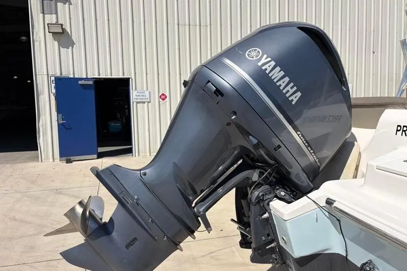 Slide: The Image of 2023 Key West 239 DFS boat with Yamaha outboard motor, parked outside a building. - 11
