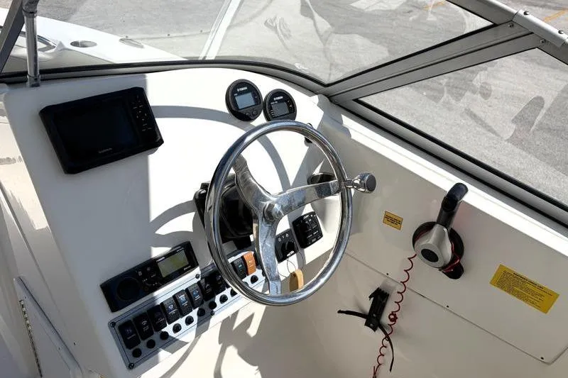 Slide: The Image of 2023 Key West 239 DFS boat dashboard with steering wheel and control panel. - 19