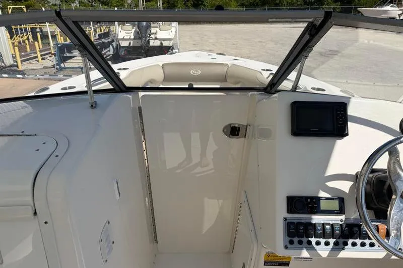 Slide: The Image of 2023 Key West 239 DFS boat dashboard with steering wheel and control panel. - 23