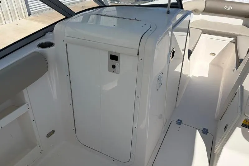 Slide: The Image of 2023 Key West 239 DFS boat interior, featuring sleek white seating and storage compartments. - 24