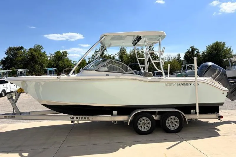 Slide: The Image of 2023 Key West 239 DFS boat on trailer under clear blue sky. - 4