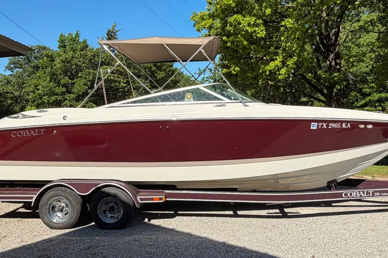 Slide: The Image of 2004 Cobalt 250 boat with teak deck, parked on a wooded road. - 10