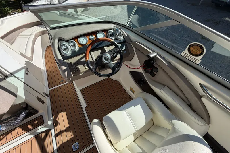 Slide: The Image of Interior of a 2004 Cobalt 250 boat with wood accents and white seating. - 13