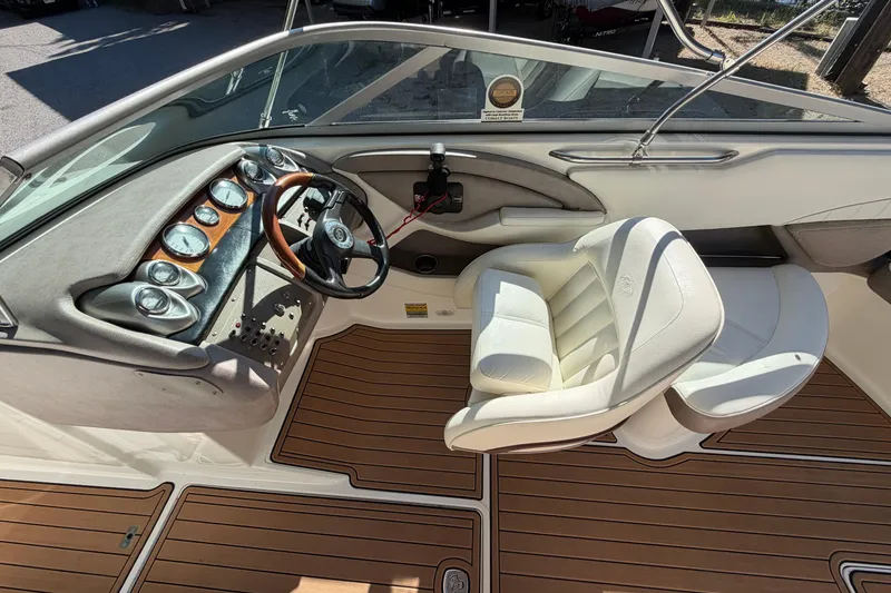 Slide: The Image of Interior of a 2004 Cobalt 250 boat featuring a sleek dashboard and comfortable seating. - 14