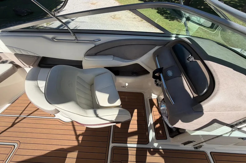 Slide: The Image of Interior of a 2004 Cobalt 250 boat with white seating and wood flooring. - 16