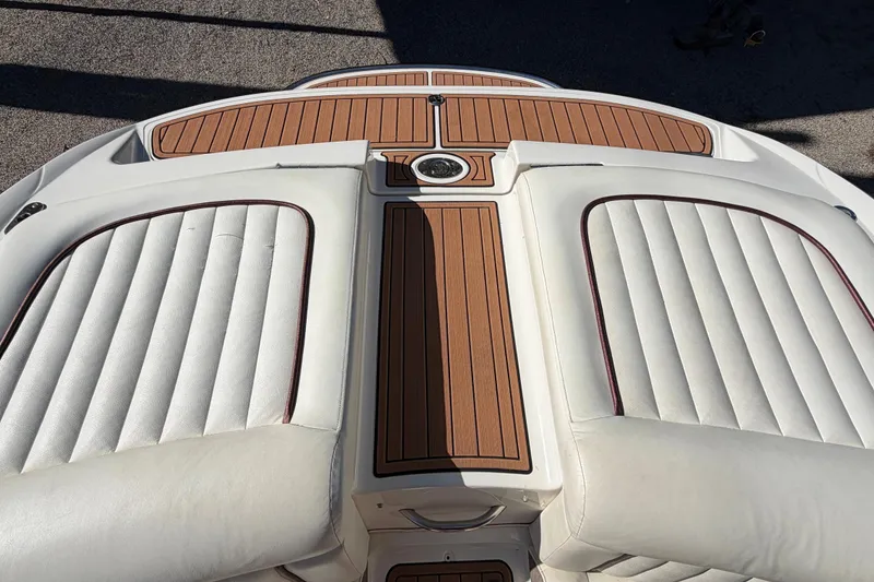 Slide: The Image of 2004 Cobalt 250 boat interior with white cushioned seats and teak flooring. - 18