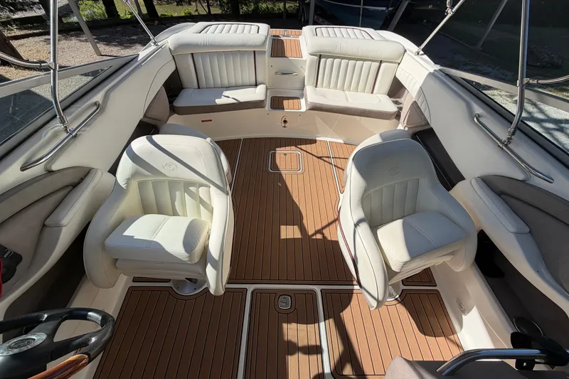 Slide: The Image of Interior of a 2004 Cobalt 250 boat with white seating and wooden flooring. - 19