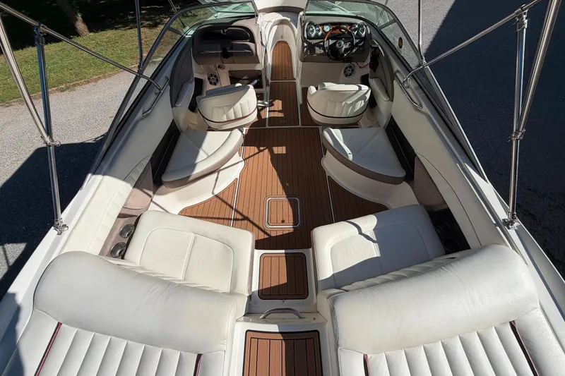 Slide: The Image of Interior of a 2004 Cobalt 250 boat with white seating and wooden flooring. - 21