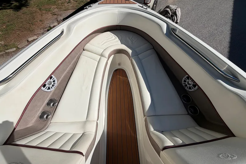 Slide: The Image of Interior of a 2004 Cobalt 250 boat with white seating and wood flooring. - 22