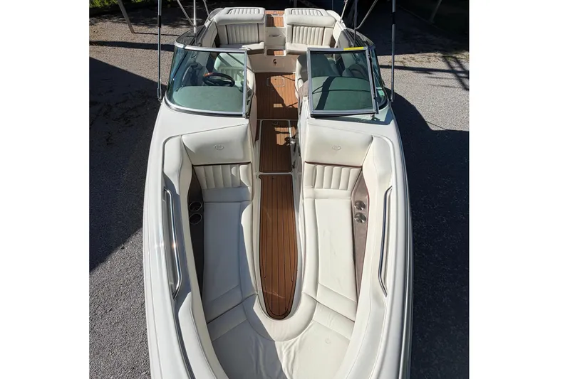 Slide: The Image of 2004 Cobalt 250 boat with white leather seating and wooden deck, viewed from above. - 23