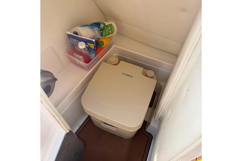Slide: The Image of Portable toilet in a 2004 Cobalt 250 boat cabin with cleaning supplies. - 24