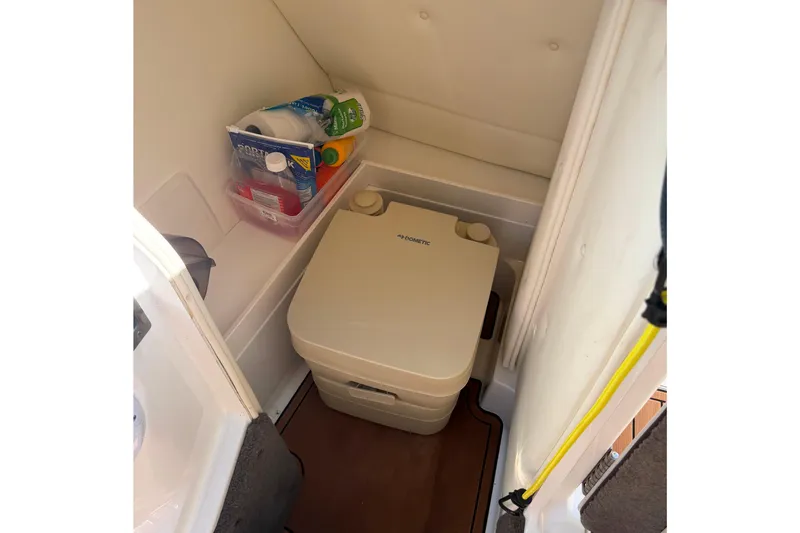 Slide: The Image of Compact boat bathroom with portable toilet and cleaning supplies, Cobalt 250, 2004 model. - 25