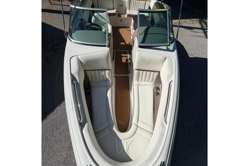 Slide: The Image of 2004 Cobalt 250 boat interior with white seating and wood accents, viewed from above. - 9
