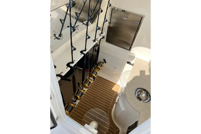 Slide: The Image of Interior of 2015 Regulator 34SS boat with fishing rods and compact kitchenette. - 4