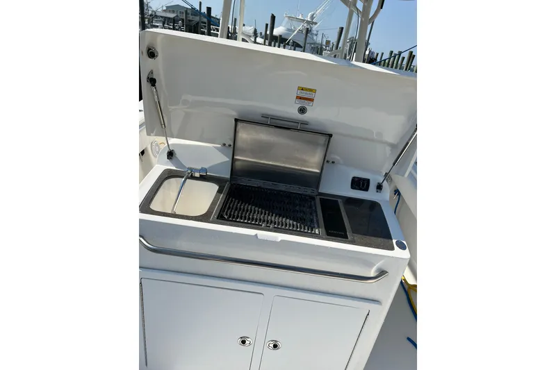 Slide: The Image of Outdoor kitchen setup on a 2015 Regulator 34SS boat with grill and sink. - 5