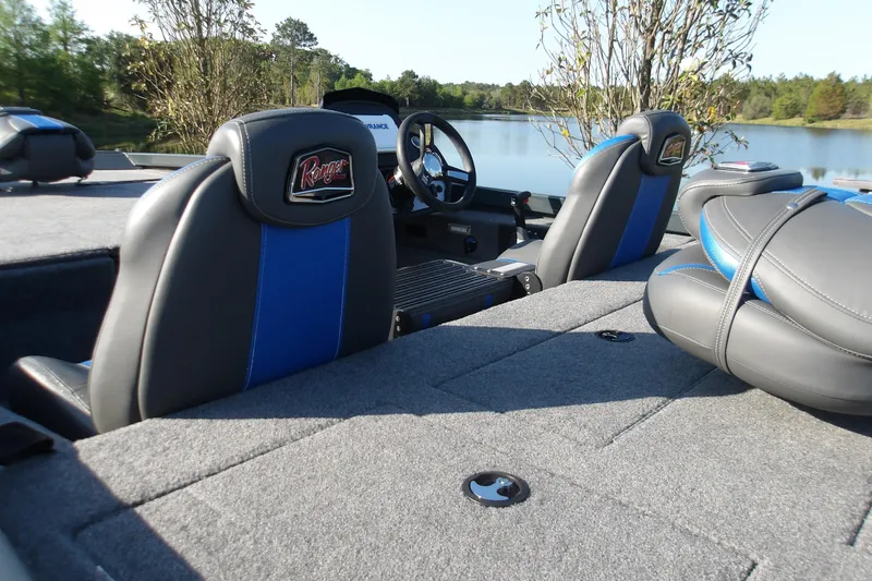 Slide: The Image of 2024 Ranger RT188P boat interior with gray and blue seating by a lake. - 7