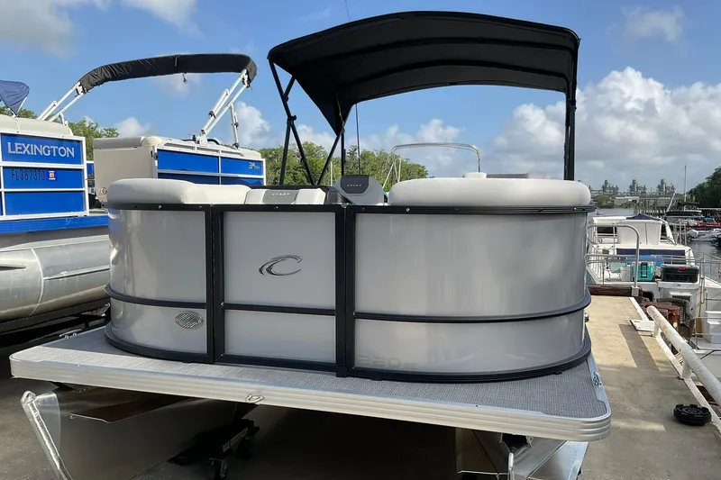 Slide: The Image of 2026 Crest Conquest SE 220 Cruise pontoon boat docked under a clear sky. - 3