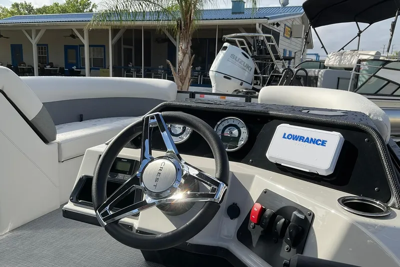 Slide: The Image of 2026 Crest Conquest SE 220 Cruise boat dashboard with steering wheel and navigation system. - 4