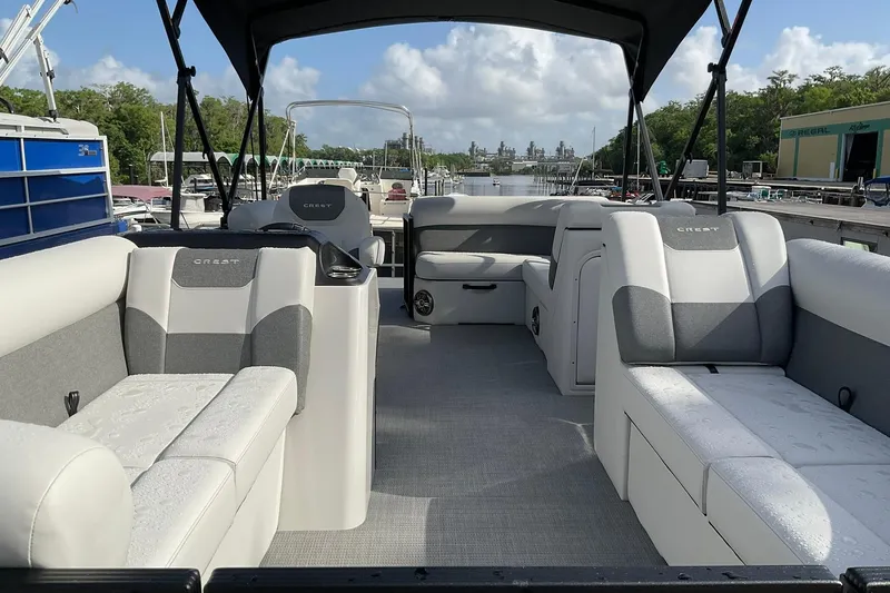 Slide: The Image of 2026 Crest Conquest SE 220 Cruise pontoon boat interior with plush seating and canopy. - 5