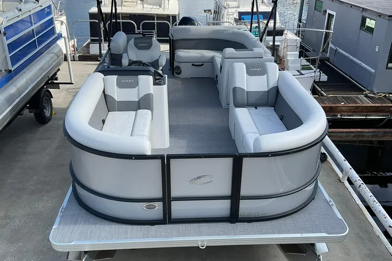Slide: The Image of 2026 Crest Conquest SE 220 Cruise pontoon boat with spacious seating at a marina dock. - 6