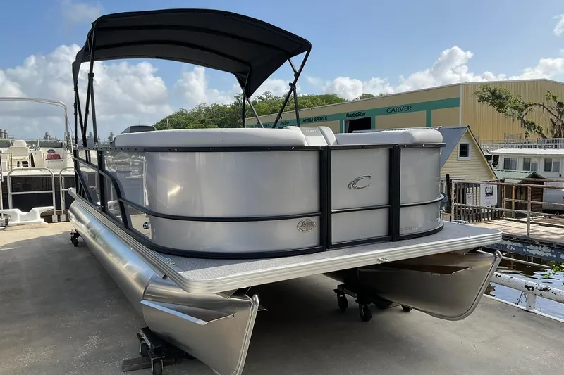 Slide: The Image of 2026 Crest Conquest SE 220 Cruise pontoon boat with canopy, docked outdoors. - 9