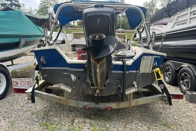 Slide: The Image of 1990 Wahoo 16.5 boat on trailer, rear view, with outboard motor and blue canopy. - 4
