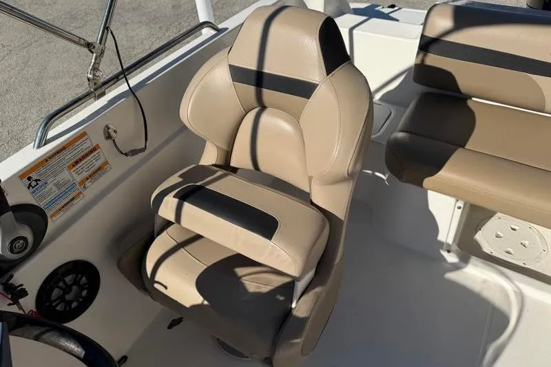 Slide: The Image of 2022 Hurricane SunDeck Sport 201 OB boat interior with beige seating and steering area. - 18