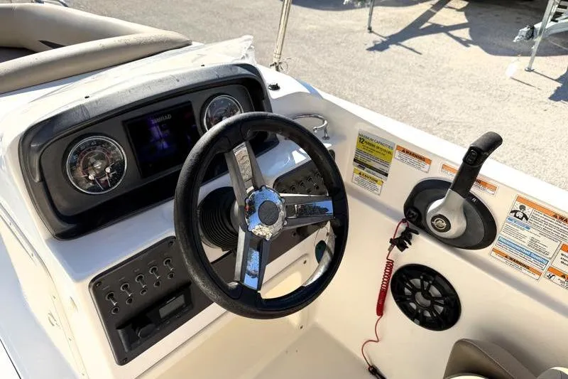 Slide: The Image of 2022 Hurricane SunDeck Sport 201 OB boat dashboard with steering wheel and controls. - 19