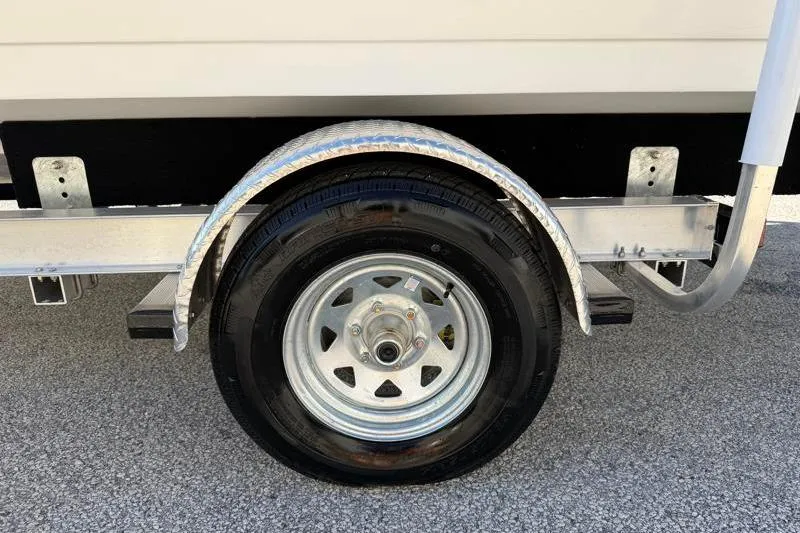 Slide: The Image of Trailer wheel of 2022 Hurricane SunDeck Sport 201 OB on asphalt surface. - 27