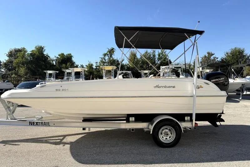 Slide: The Image of 2022 Hurricane SunDeck Sport 201 OB boat on trailer, featuring a sleek design and canopy. - 4