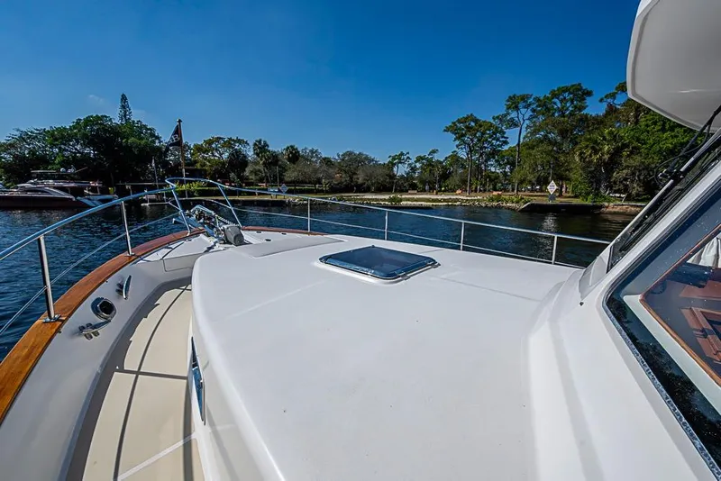 Slide: The Image of 2013 Grand Banks 43 Europa yacht on calm water, surrounded by lush greenery. - 12