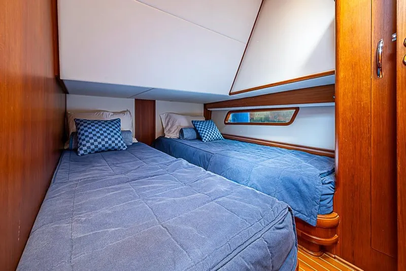 Slide: The Image of Cozy twin cabin in 2013 Grand Banks 43 Europa yacht with blue bedding and wooden accents. - 54