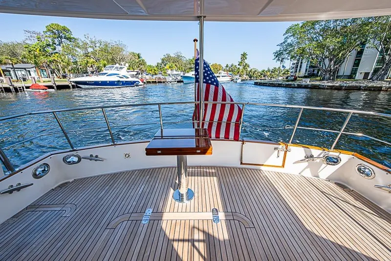 Slide: The Image of 2013 Grand Banks 43 Europa yacht deck with American flag, overlooking serene waterfront. - 9