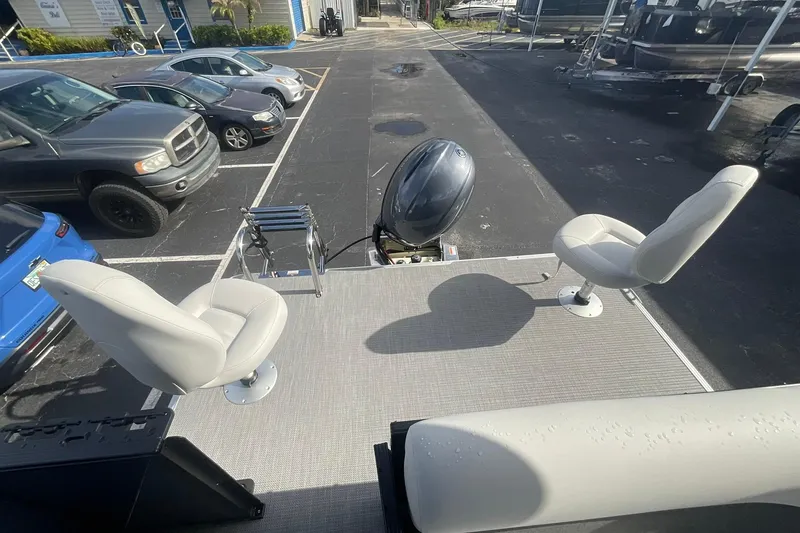 Slide: The Image of 2026 Crest Conquest SE 220 Fish boat with dual seats and outboard motor in parking lot. - 4