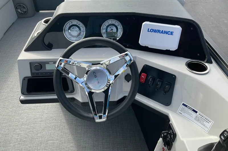 Slide: The Image of 2026 Crest Conquest SE 220 Fish dashboard with steering wheel and Lowrance display. - 7