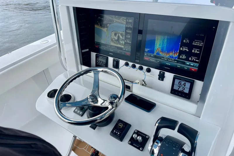 Slide: The Image of Control panel of a 2016 Bahama 41 boat with navigation screens and steering wheel. - 10